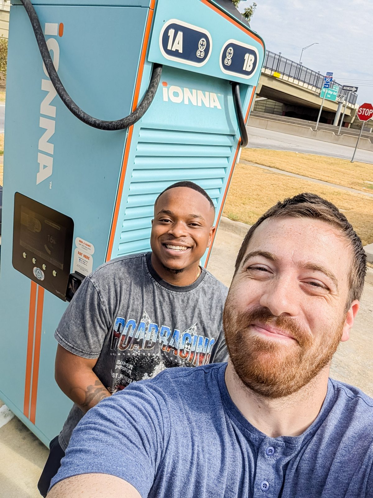 Two Station Hands taking a selfie in front of an IONNA charging dispenser